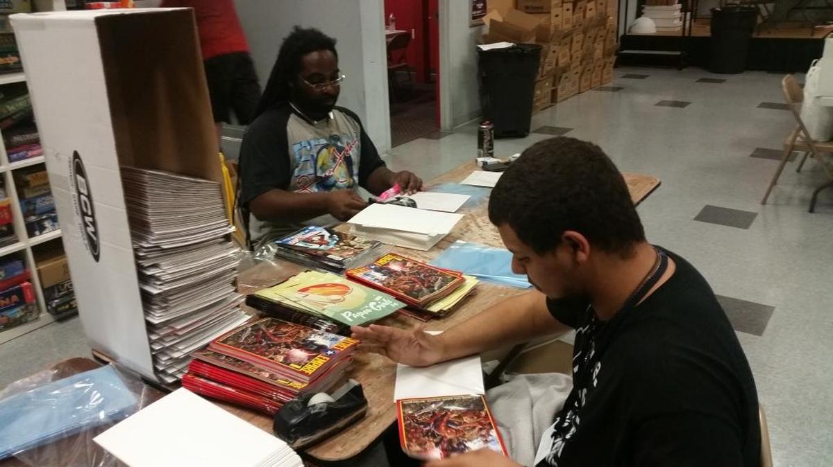 C.J. Jones, right, and Jeff McNeil bag comics at Atomic Empire on Tuesday.