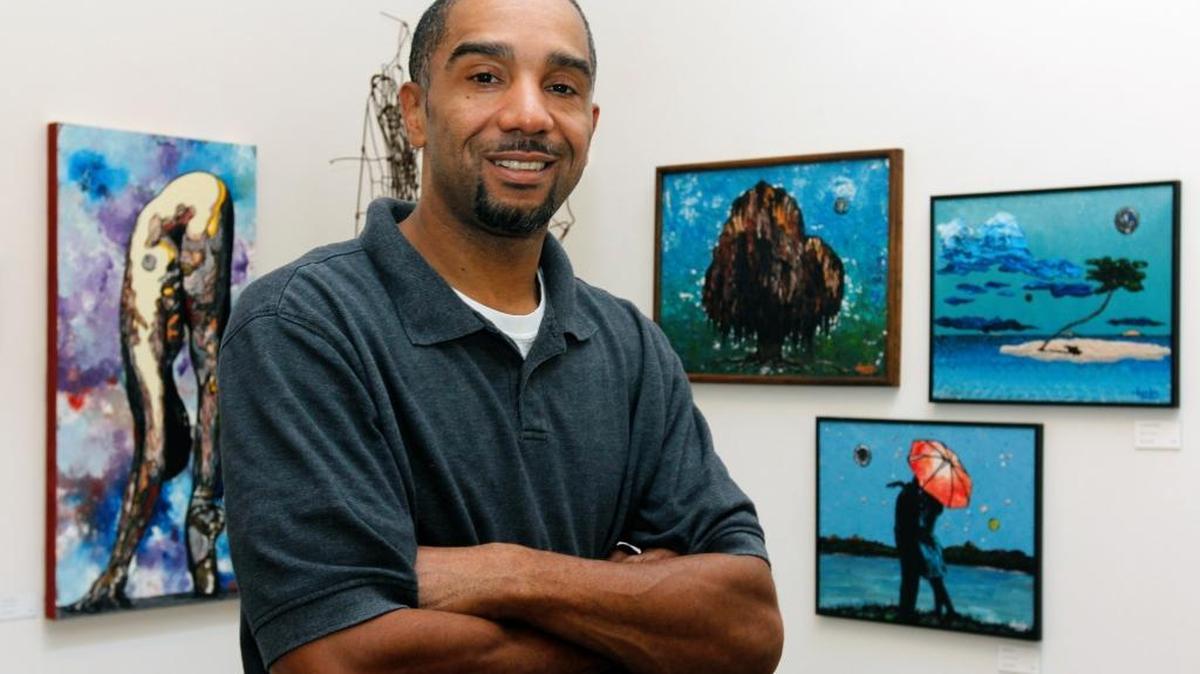 Durham artist Darius Quarles, one of the members of Pleiades Gallery on East Chapel Hill Street, with a display of some of his acrylics on canvas Friday, June 13, 2014. The gallery is becoming a non-profit.