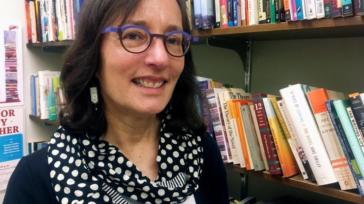 In this Monday, May 1, 2017, photo, author Julie Schumacher poses for a photo in her University of Minnesota office in Minneapolis. Schumacher wrote the satirical adult coloring book "Doodling for Academics" that pokes fun at the collegiate world by following a day in the life of a student or teacher.