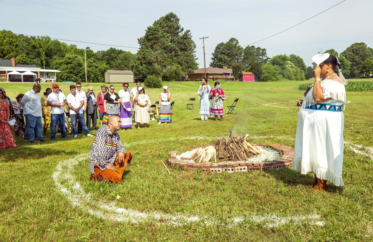 Jason 'Crazy Bear' Keck, left, and Crystal Cavalier exchange vows standing in a cornmeal-marked circle with a fire facing the East to symbolize their new beginning as a married couple during their traditional Native American wedding ceremony on Saturday, Jun. 9, 2018, in Mebane, NC.