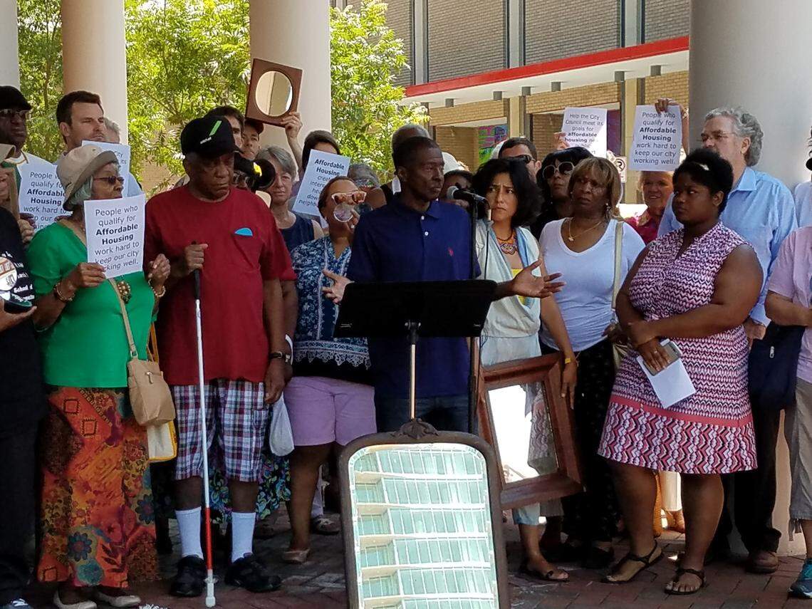 Wilbert Pipkin said that he has had a hard time finding affordable housing in Durham after getting out of prison a little over a year ago.  The mirror in front of him reflects the under construction high rise One City Center.