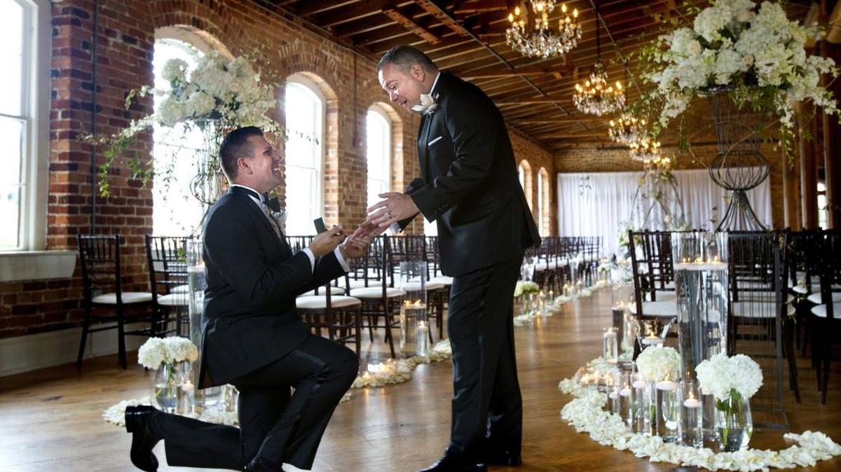 Chad Biggs, left, gets down on one knee to surprise his husband, Chris Creech, with the wedding bands they had ordered before the start of their wedding ceremony. Creech had been told that they wouldn't arrive in time for their wedding. After almost a year of planning, Chad Biggs and Chris Creech celebrated with friends at their formal wedding at Melrose in Raleigh, N.C. on Saturday, September 26, 2015.