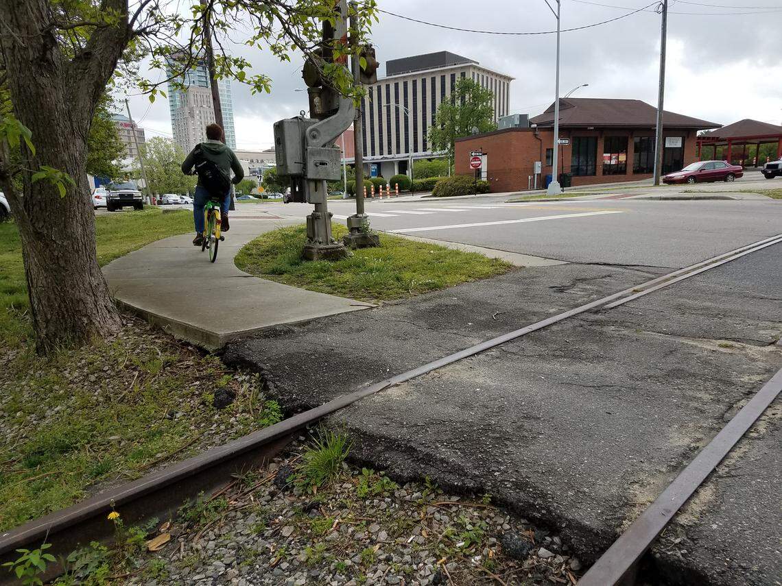 A bicyclist passes the old Durham Belt Line railroad tracks on a Lime Bike in downtown Durham on Wednesday, April 25, 2018. The Belt Line will be turned into an urban trail if a master plan comes to fruition.