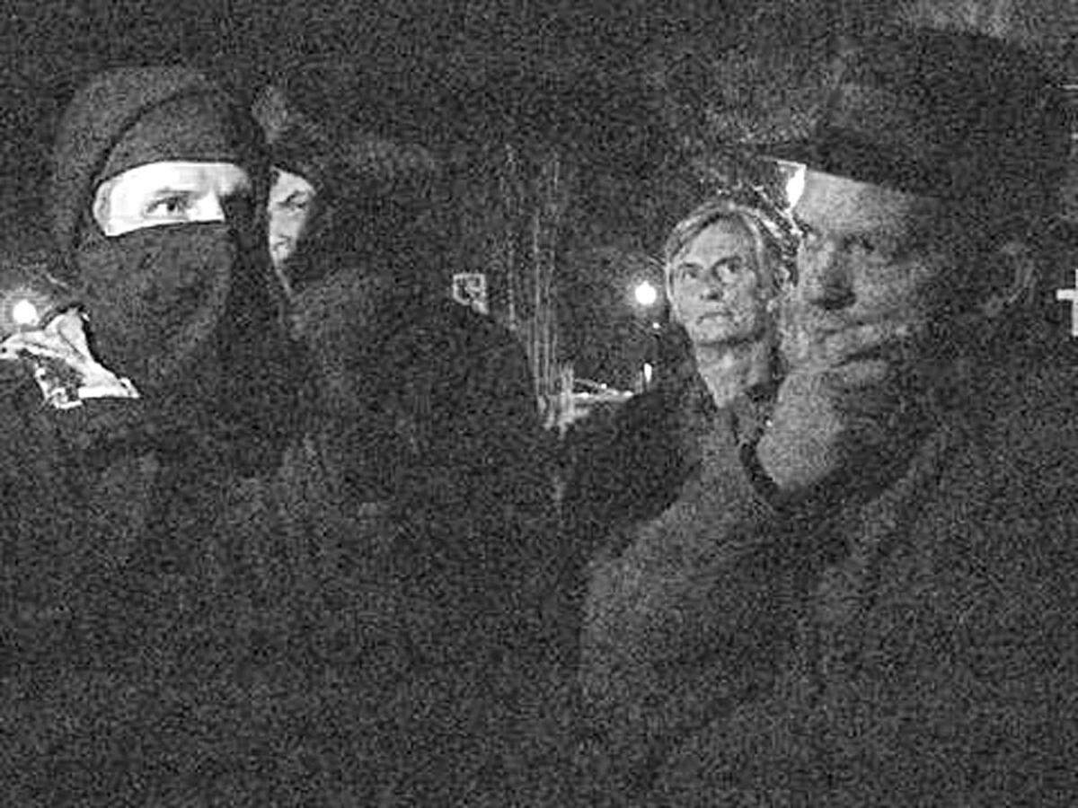 Then Carrborro Mayor Mark Chilton, right, listens to a masked, self-described anarchist after he and police ordered a group of activists to leave the abandoned WCOM radio station building at Weaver and North Greensboro streets in 2012.