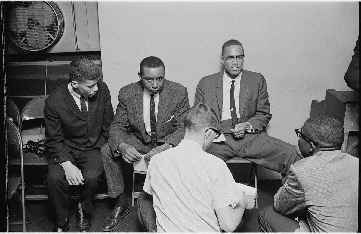 Durham high school student and NAACP member Walter Riley, left, moderated the debate between attorney and civil rights activist Floyd McKissick Sr., looking at camera, and black nationalist Malcolm X, right, in Durham in 1963.