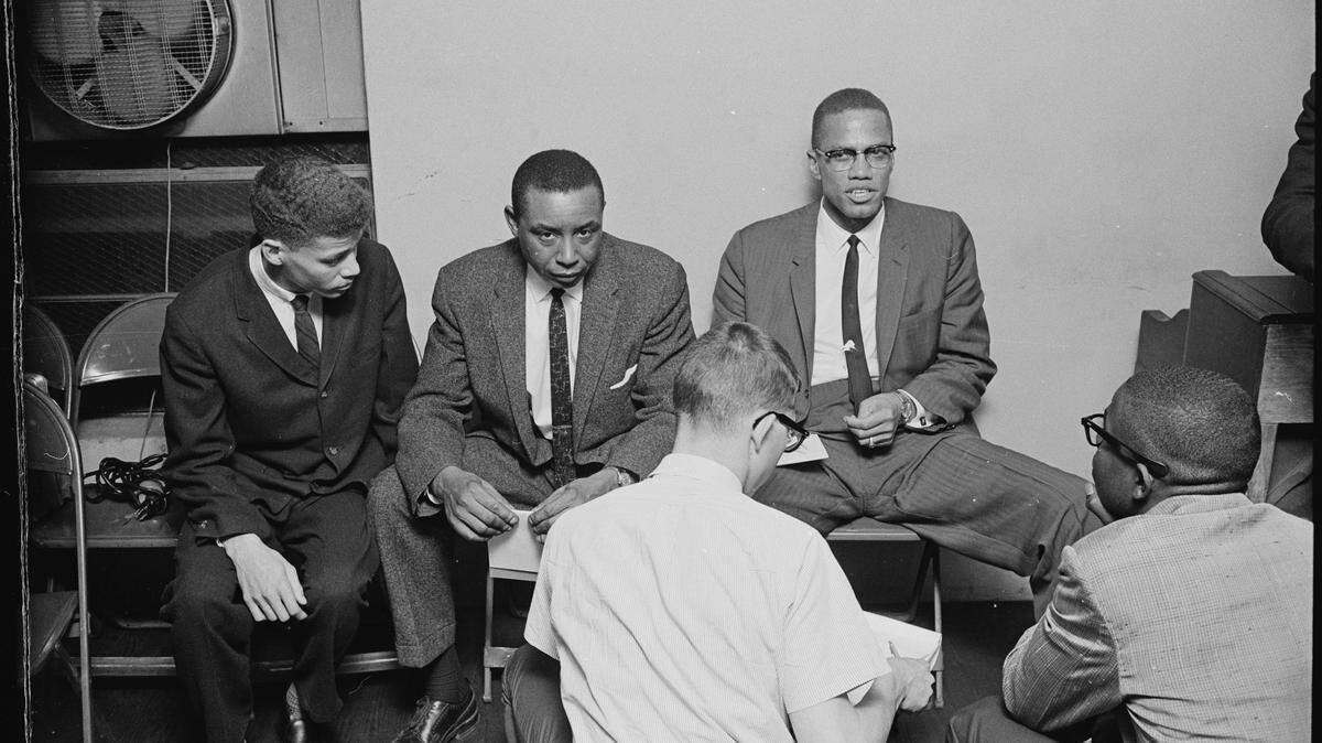 Durham high school student and NAACP member Walter Riley, left, moderated the debate between attorney and civil rights activist Floyd McKissick Sr., looking at camera, and black nationalist Malcolm X, right, in Durham in 1963.