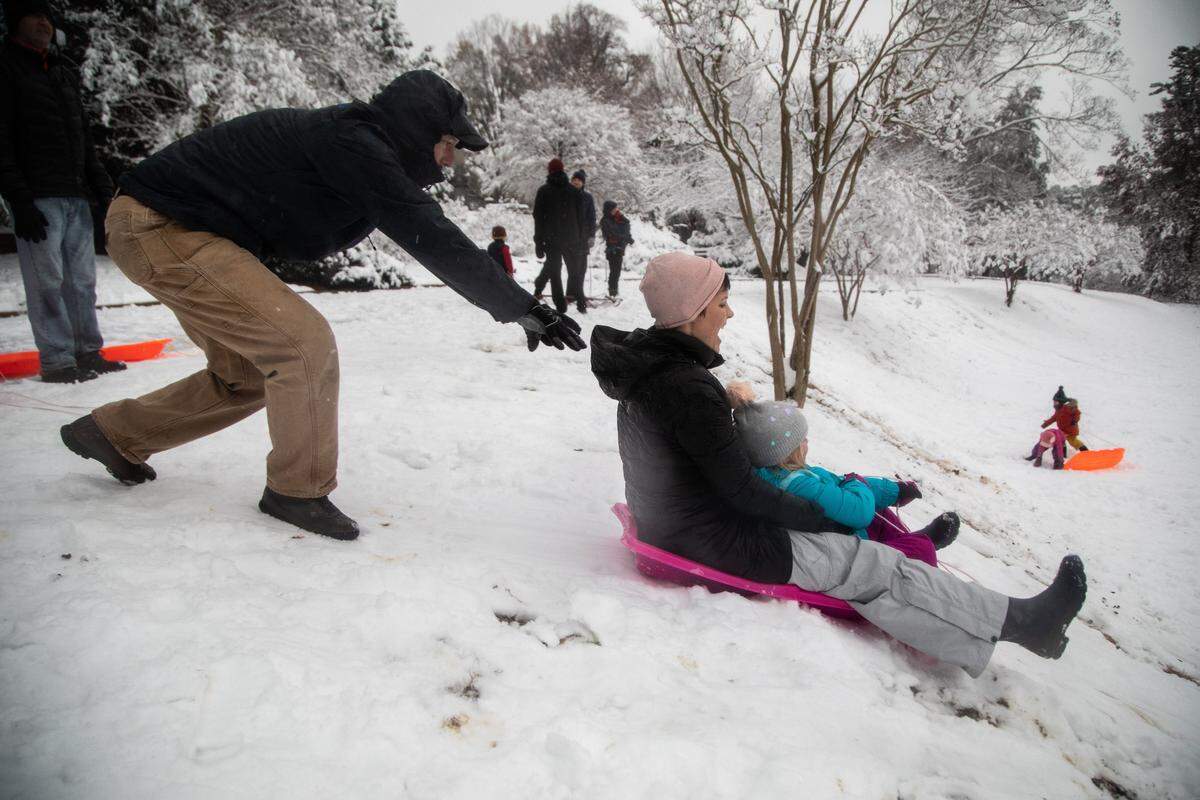 Robby Johnston gives his wife Ryan and daughter Annie, 5, a push on their sled Sunday, Dec. 9, 2018 in Raleigh’s Oakwood Cemetery.