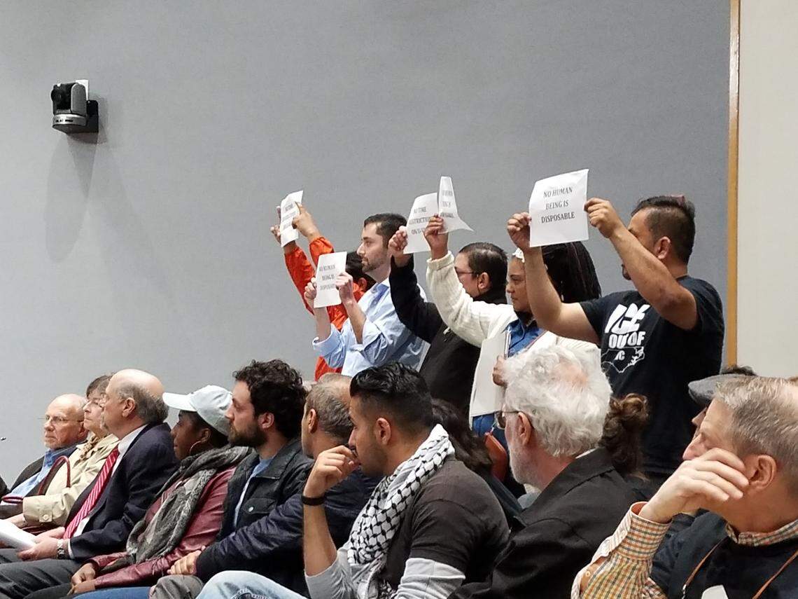 While Durham City Council member Javiera Caballero read a statement about ICE arrests during the Monday, April 16, 2018 council meeting, five people in the audience silently held up signs that said "No human being is disposable" and "No time restrictions on U-Visas."