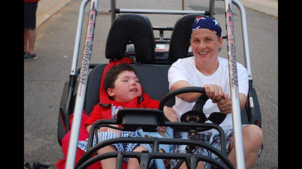 David Stuart, left, and Lori Stuart in a go-kart purchased for David to ride in his Raleigh neighborhood after a go-kart business wouldn't let him ride.