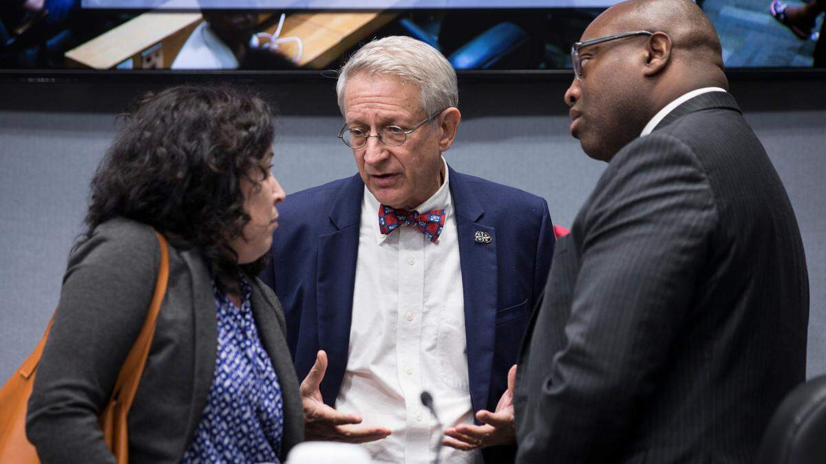 Durham City Council members Javiera Caballero, left, and Mark-Anthony Middleton, right, speak with Mayor Steve Schewel, middle, ahead of a City Council meeting on Monday, August 6, 2018. The council voted 5-2 to reject a charter school financing, with Schewel and Caballero voting down the financing and Middleton supporting it.