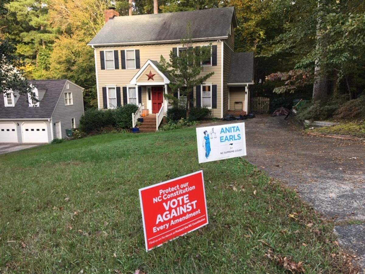 Campaign yard signs in front of the home of Sarah Bickley and John O’Brien, who live in Woodcroft. They were told to take down an “In Our America” sign that includes the phrases “Black Lives Matter” and “Love Wins.”