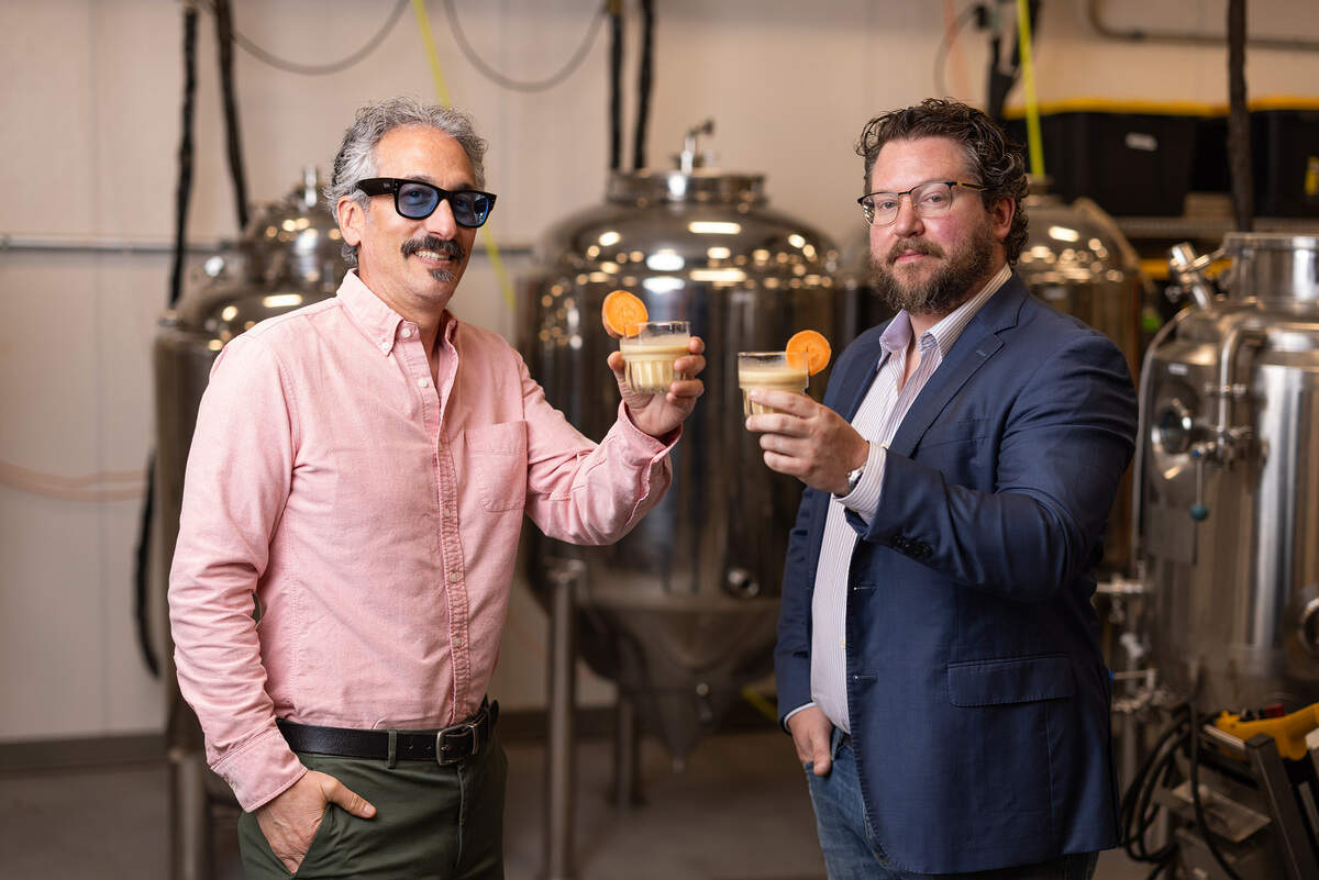 App State professor Brett Taubman, left, and Fermentation Sciences Lab manager Daniel Parker show off their creation in their facility. The Appalachian State University researchers, backed by a $1.82 million grant, have found a new use for sweet potatoes: sweet potato milk.