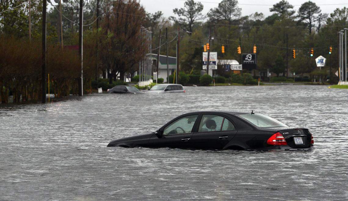 Abandoned cars  sit in floodwaters near College Street Sunday in Wilmington.