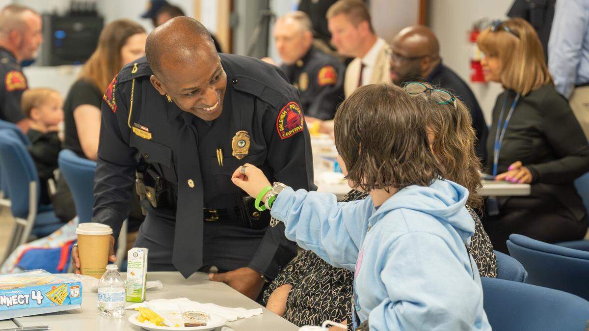 Raleigh Police Department Chief Rico Boyce shows a community member his badge.