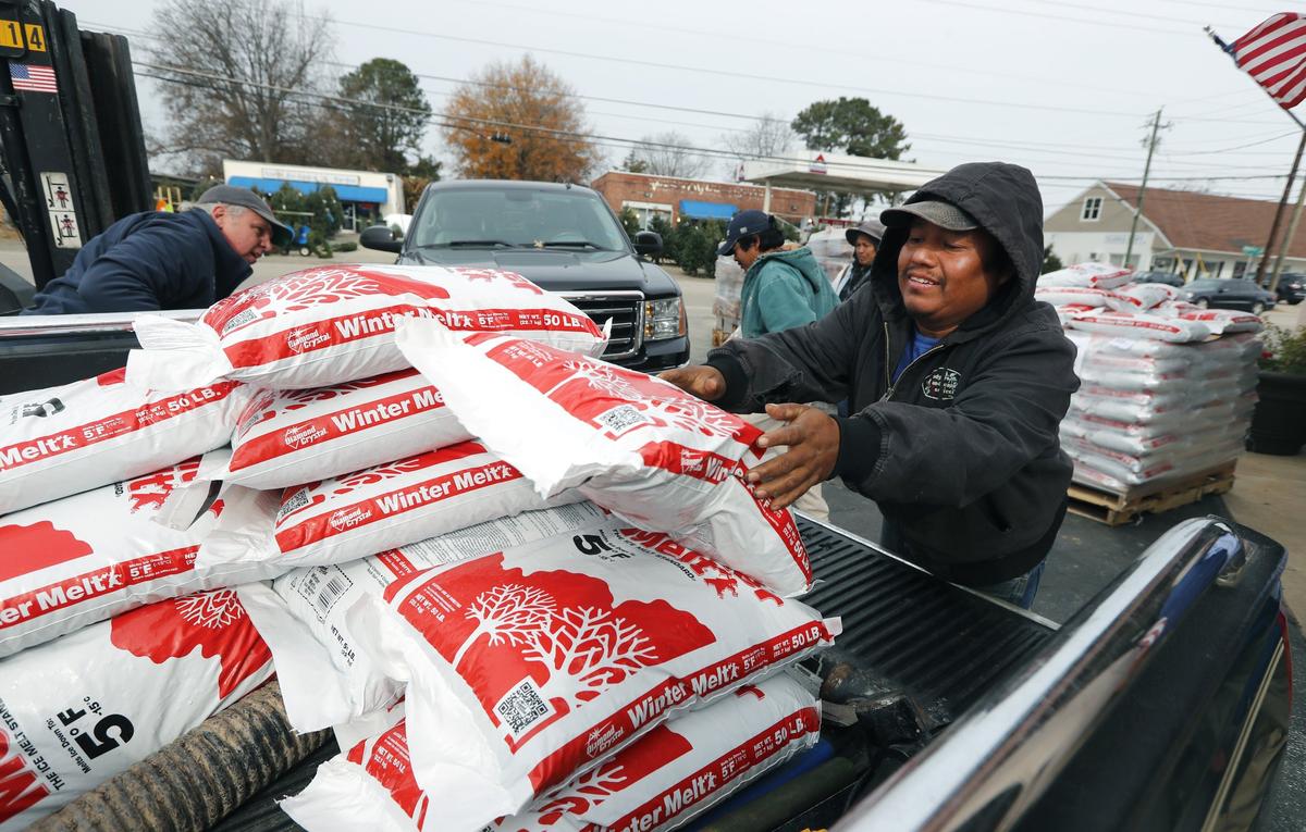 Gregory Mendez with Diaz Landscaping helps load a truck with bags of Winter Melt at Burke Brothers Hardware in Raleigh, N.C., Saturday, Dec. 8, 2018.