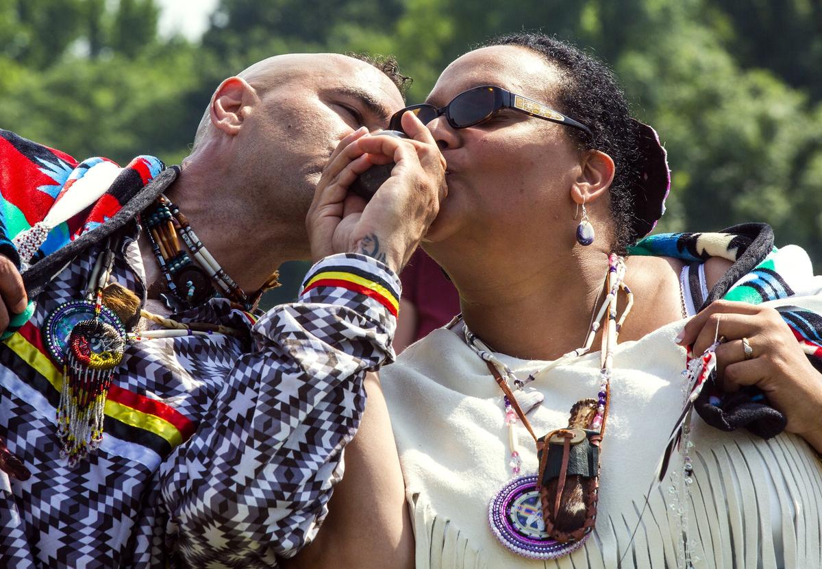 Jason Crazy Bear Keck, left, and Crystal Red Bear Cavalier drink water from a double-spouted pot during their traditional Native American wedding ceremony on Saturday, Jun. 9, 2018, in Pleasant Grove, NC.