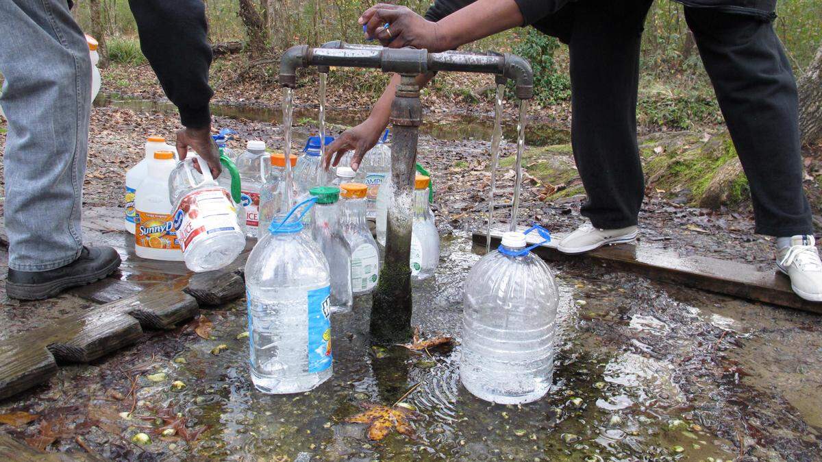 Levi Hayes Jr. and Carolyn Hayes fill up bottles of water at the Healing Springs at God's Acre on Friday, Dec. 5, 2014, in Blackville, S.C. People have thought the natural springs have supernatural healing powers ever since four gravely wounded British soldiers recovered after drinking from them in 1781. Recently, entrepreneurs have begun bottling untreated spring water, sometimes called "raw water," for sale.