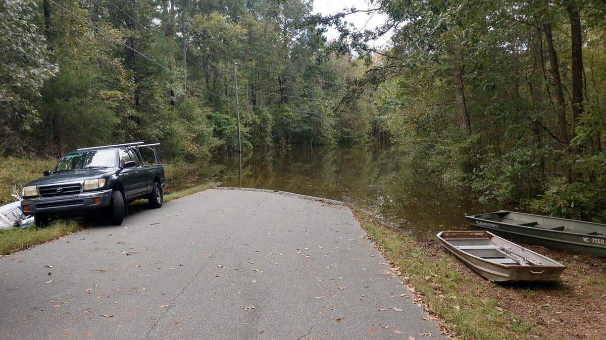 Residents of Jeremiah Drive park on side of the flooded road and use boats to get across to their neighborhood near Jordan Lake.