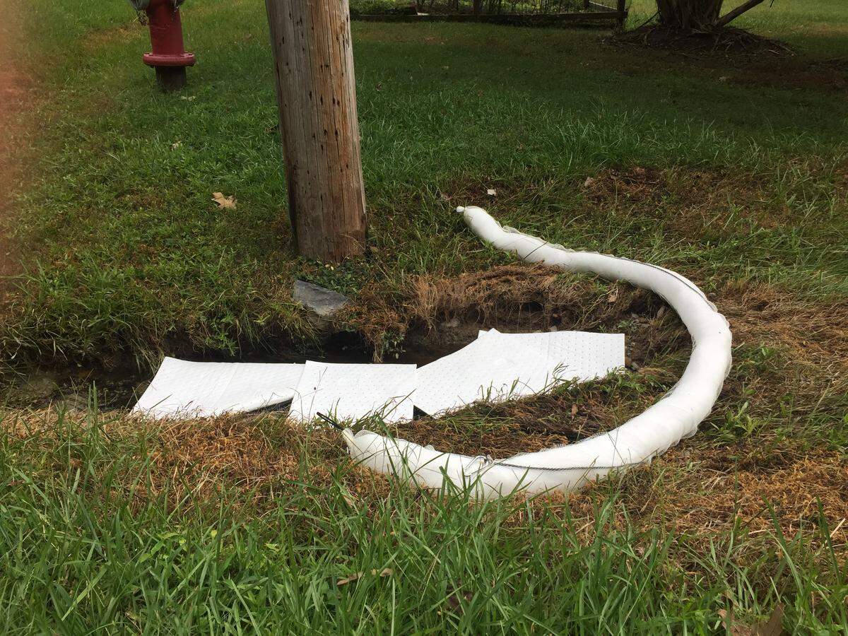 Carrboro town workers installed hazmat absorbent booms and pads in ditches leading to Tom’s Creek that were contaminated by fuel oil spill in the Plantation Acres neighborhood.