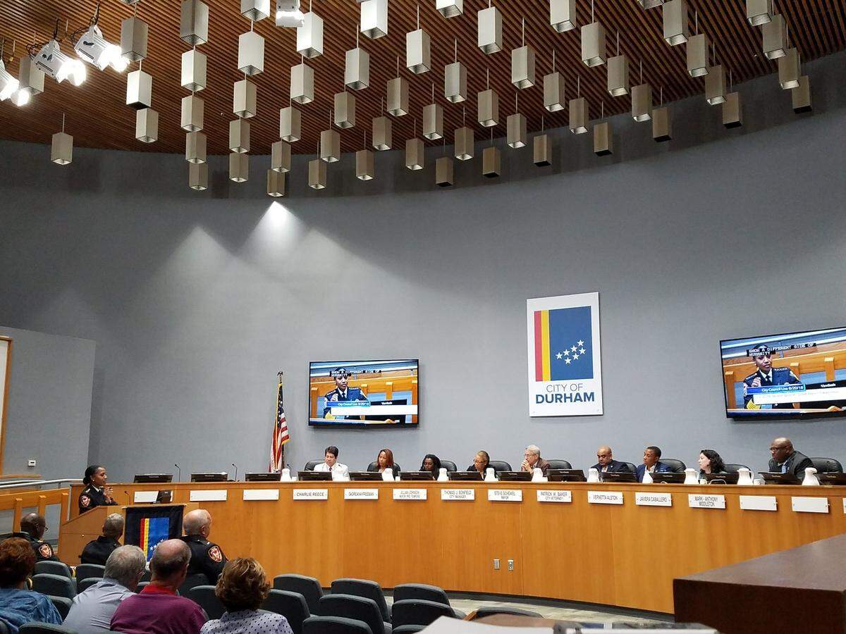 Durham Police Chief Cerelyn “C.J.” Davis, left, at lecturn, addresses Durham City Council on Monday, Aug. 20, 2018. Left to right on the dais are Council member Charlie Reece, Council member DeDreana Freeman, Mayor Pro Tem Jillian Johnson, Deputy City Manager Wanda Page, Mayor Steve Schewel, City Attorney Patrick Baker, Council member Vernetta Alston, Council member Javiera Caballero and Council member Mark-Anthony Middleton.