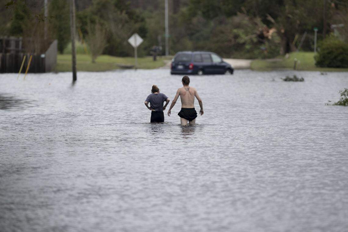 Amanda Mason and Zack McWilliams on Newport, N.C. walk through waist deep water to take a look at their flooded home off of Nine Foot Road on Sunday afternoon September 16, 2018. The were displaced on Friday night after fast rising water entered their home from a tributary of the Newport River.