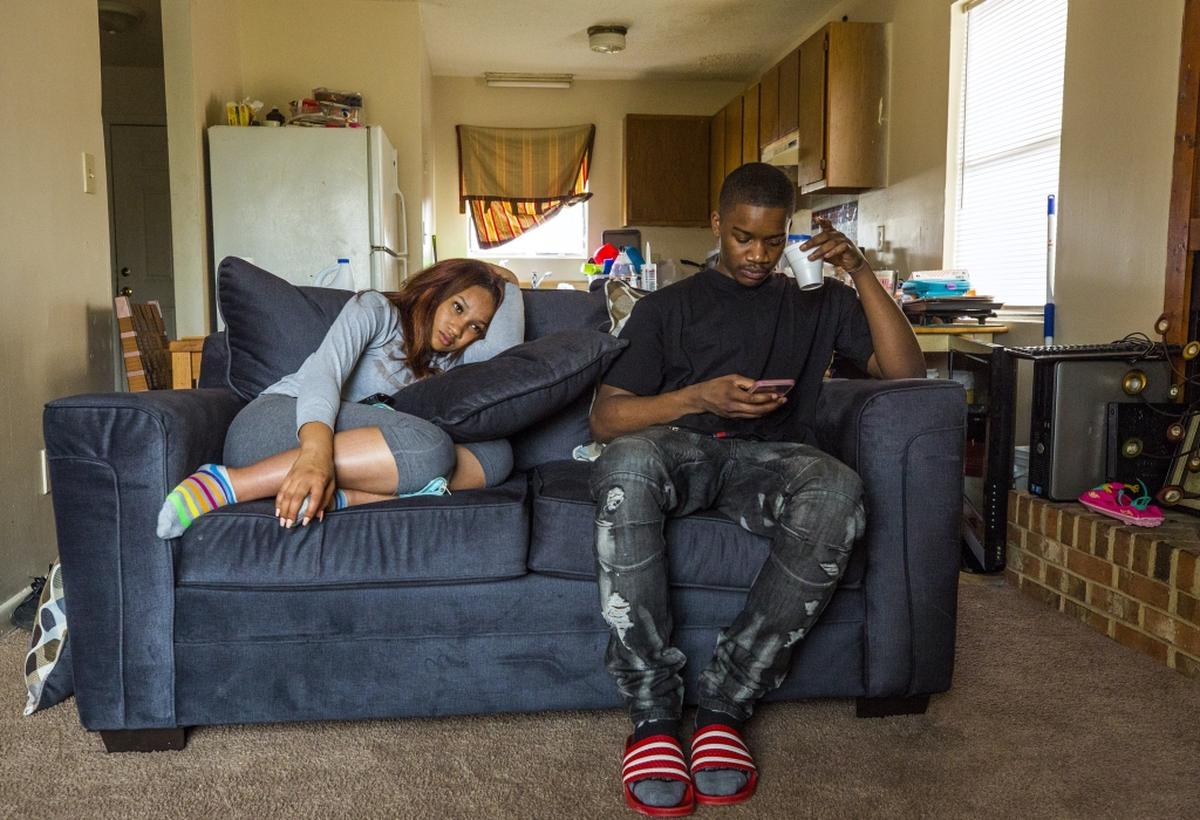 Ledarius Samuel scrolls on his girlfriend, Katiyah Jones', iPhone while watching a moving together on Wednesday, Mar. 28, 2018, in Durham, NC. Samuel was charged with murder in 2017 and spent 376 days in jail before being released on an unsecured bond due to weak evidence. The day after the Herald-Sun published a story about Samuel's release on Mar. 6, he was arrested during a traffic stop for multiple charges and spent 20 more days in jail before the charges were all dropped.