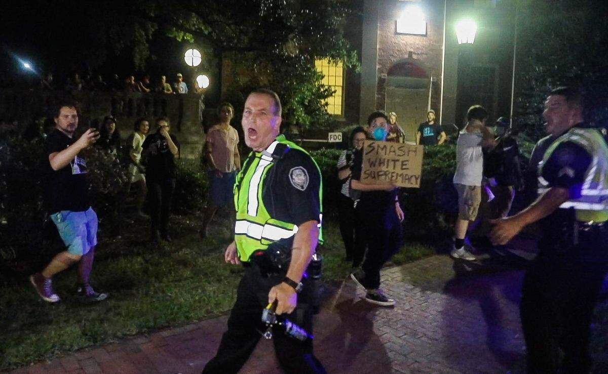 Greensboro Police Capt. Jonathan Franks is visibly agitated after pointing a pepper spray canister at a protester’s face during a rally and counter protest over the Silent Sam Confederate monument Thursday, August 30, 2018, at UNC-Chapel Hill. Police deployed pepper spray while trying to keep Confederate monument supporters and protesters separated.