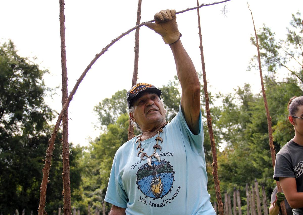 John “Blackfeather” Jeffries, 79, is working with volunteers to rebuild a replica Native American village in honor of his Occaneechi ancestors along the Eno River in Hillsborough, North Carolina. Here he bends a cedar sapling to show how the wood will frame a small hut.