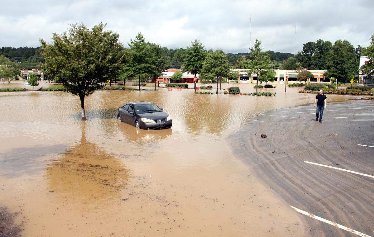 Steve Hammer, 40 , looks at his Pontiac G6, which he had left at Eastgate Crossing on Sunday night. He said the water peaked at the door handles before subsiding.