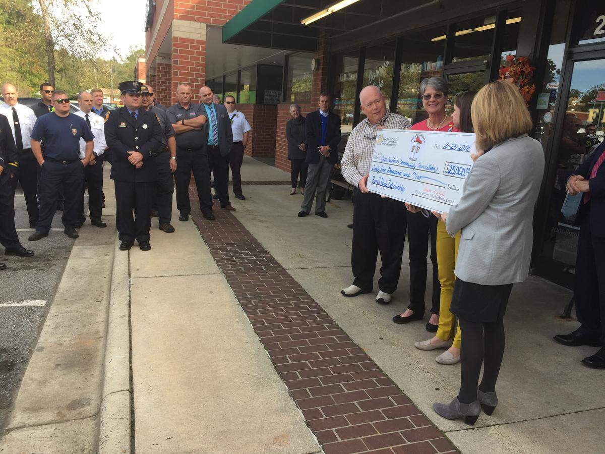 Denise Doyle (second from left) presents a check in honor of her husband Barry, who started Feed the Firefighters, a nonprofit aimed at supporting Wake County first responders.
