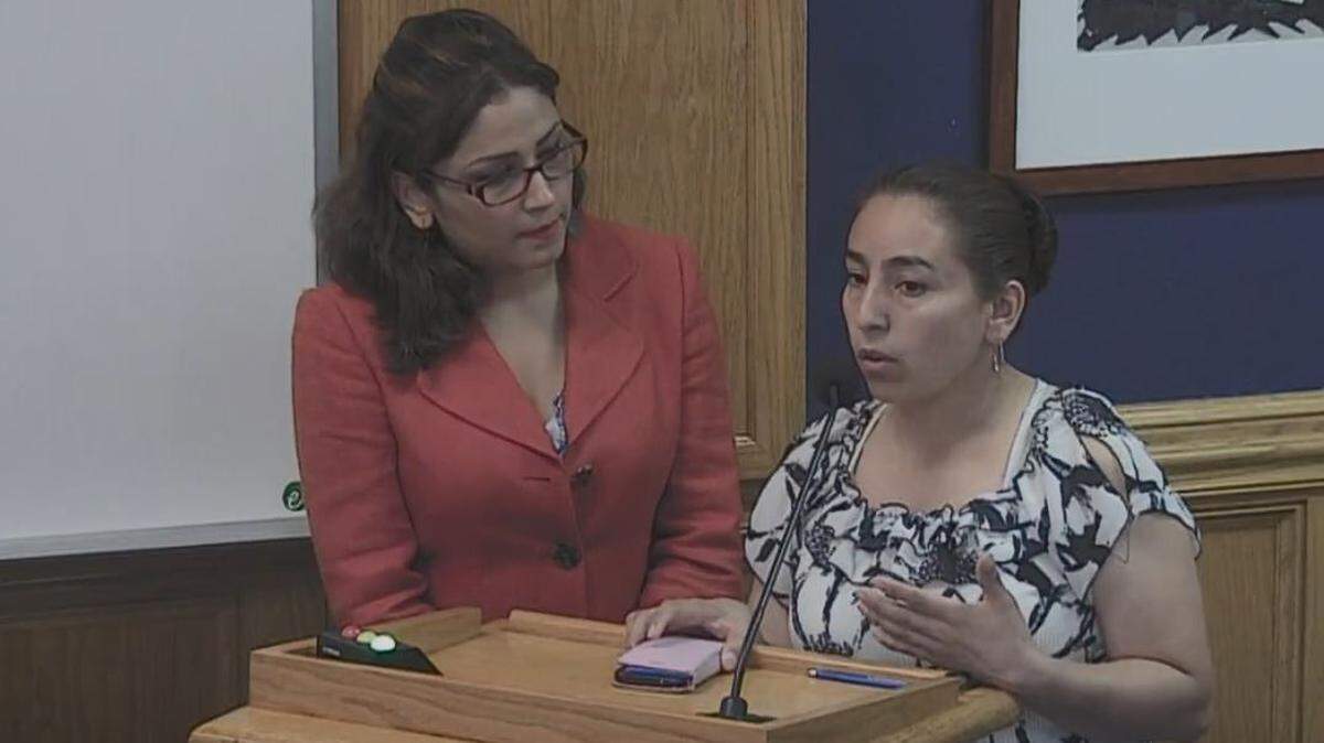 Alexandra Valladares (left), a Durham parent and community activists, helps an unidentified Hispanic mother share concerns about her child's academic progress during a recent school board meeting.