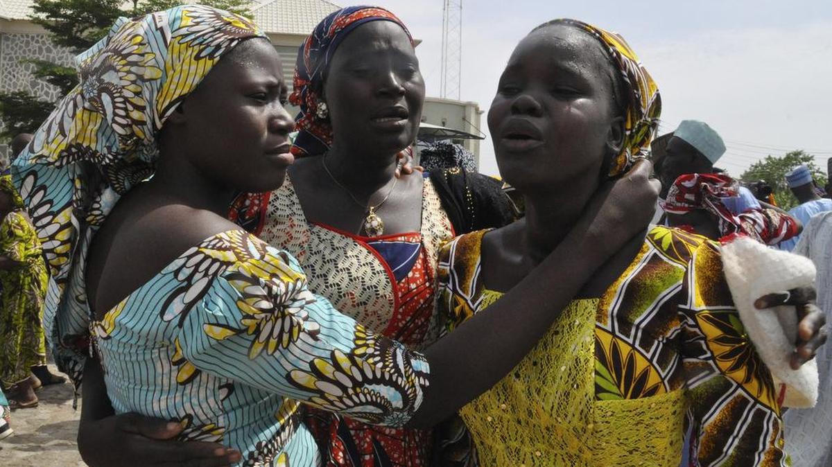Family members celebrate as they embrace a relative, one of the released kidnapped schoolgirls, in Abuja, Nigeria, Saturday.