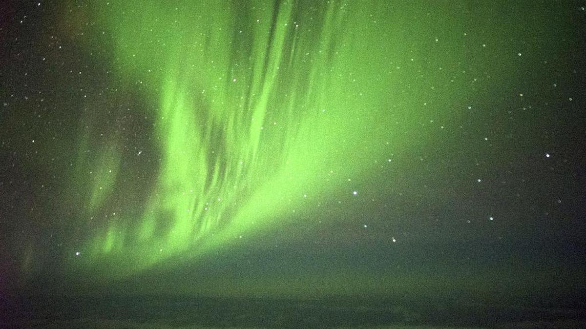 The Southern Lights are seen over the Southern Ocean near Antarctica from a chattered plane.