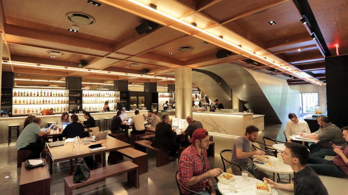 In this June 1, 2017 photo, people dine in the Louis space in the lobby of the PUBLIC hotel, in New York. The area is part grocery, part coffee shop, and part luncheonette.