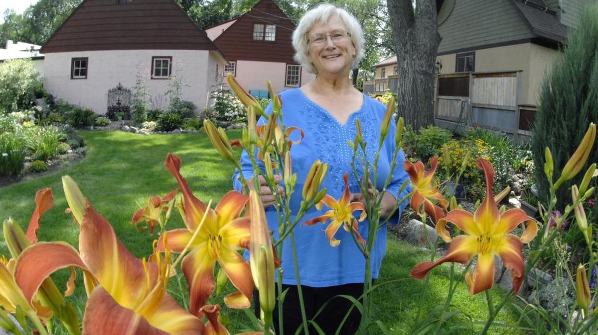 Susan Holland is surrounded in the backyard of home by blooming plants and flowers including a stand of daylilies in Bismarck, N.D. Holland is a member of the Central North Dakota Daylily Society.