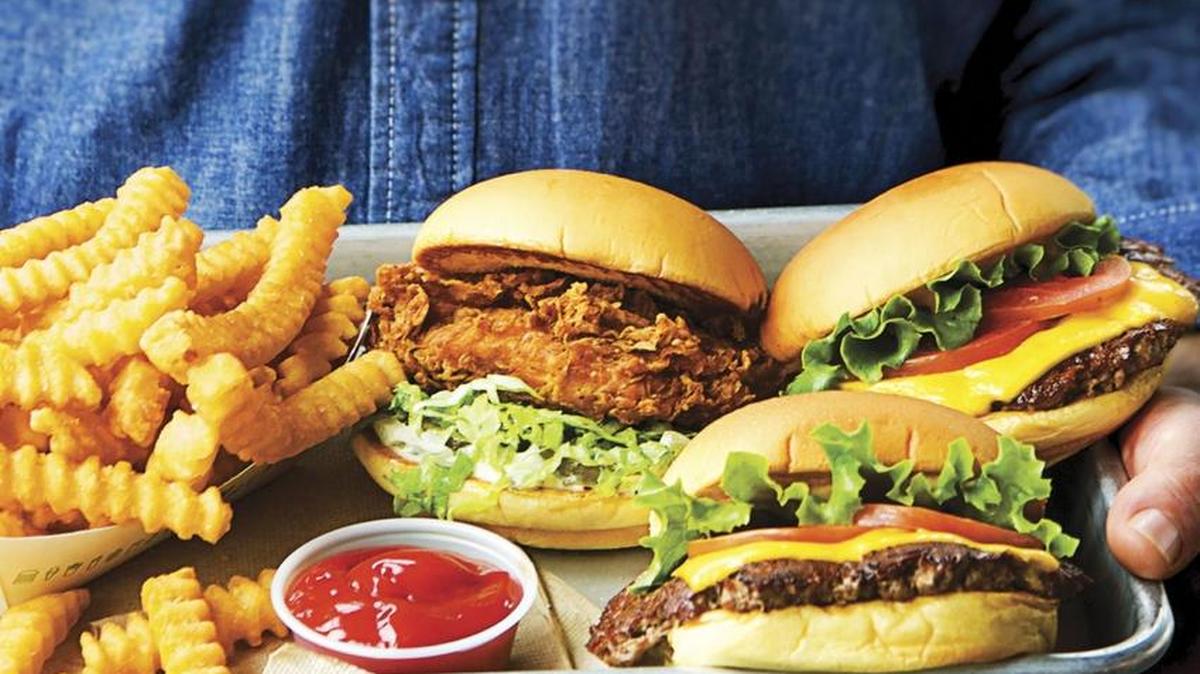 This image provided by Penguin Random House shows the cover of the book "Shake Shack: Recipes & Stories." The book was co-written by Shake Shack's CEO, Randy Garutti, and culinary director Mark Rosati.