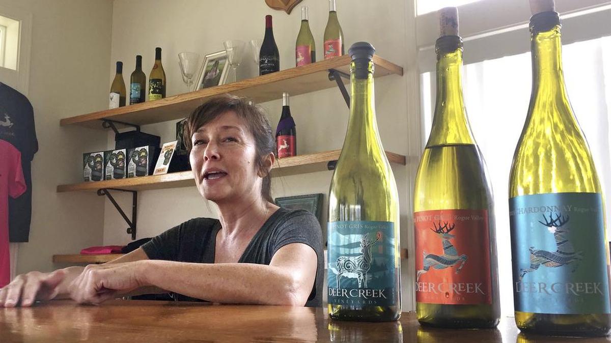 In this April 5, 2017 photo, vineyard owner Katherine Bryan laughs as she discusses the wines available for tasting at Deer Creek Vineyards in Selma, Ore. Bryan is one of a handful of vineyard owners and winemakers in this fertile corner of southwestern Oregon who are branching out into marijuana farming after the legalization of recreational weed in Oregon two years ago.