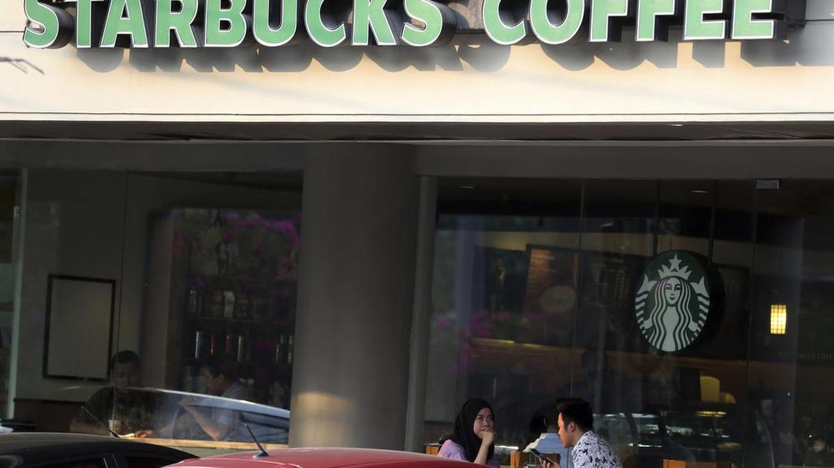 An Indonesian couple sit at Starbucks Coffee shop in Jakarta, Indonesia. Muslim groups in Malaysia and Indonesia have called for a boycott of Starbucks because of the coffee chain's support for LGBT rights.