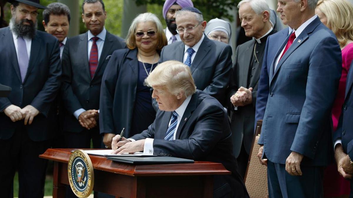 In this Thursday, May 4, 2017 file photo, President Donald Trump signs an executive order aimed at easing an IRS rule limiting political activity for religious organizations, in the Rose Garden of the White House in Washington. The order is drawing a mix of enthusiasm and dread from religious leaders, with some rejoicing in the freedom to preach their views and others fearing it will lead to awkward situations and erode the integrity of the church.