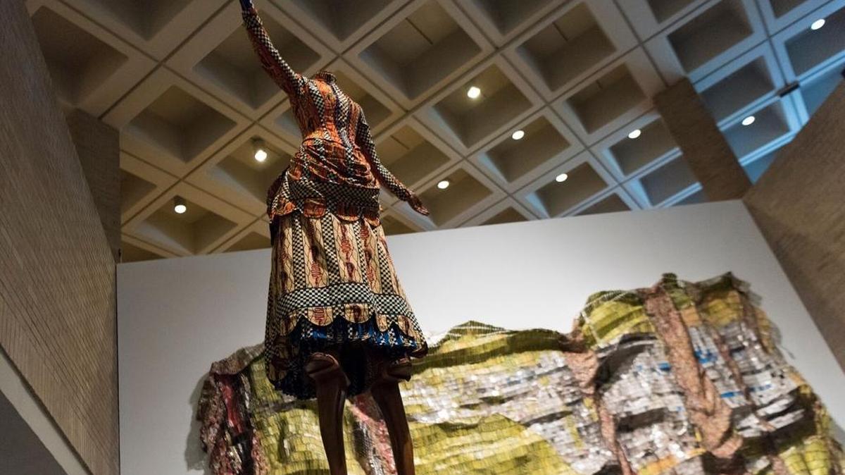 The N.C. Museum of Art’s African Art Gallery features “Eleanor Hewitt” by Yinka Shonibare (foreground) and “Lines That Link Humanity” by El Anatsui (rear).