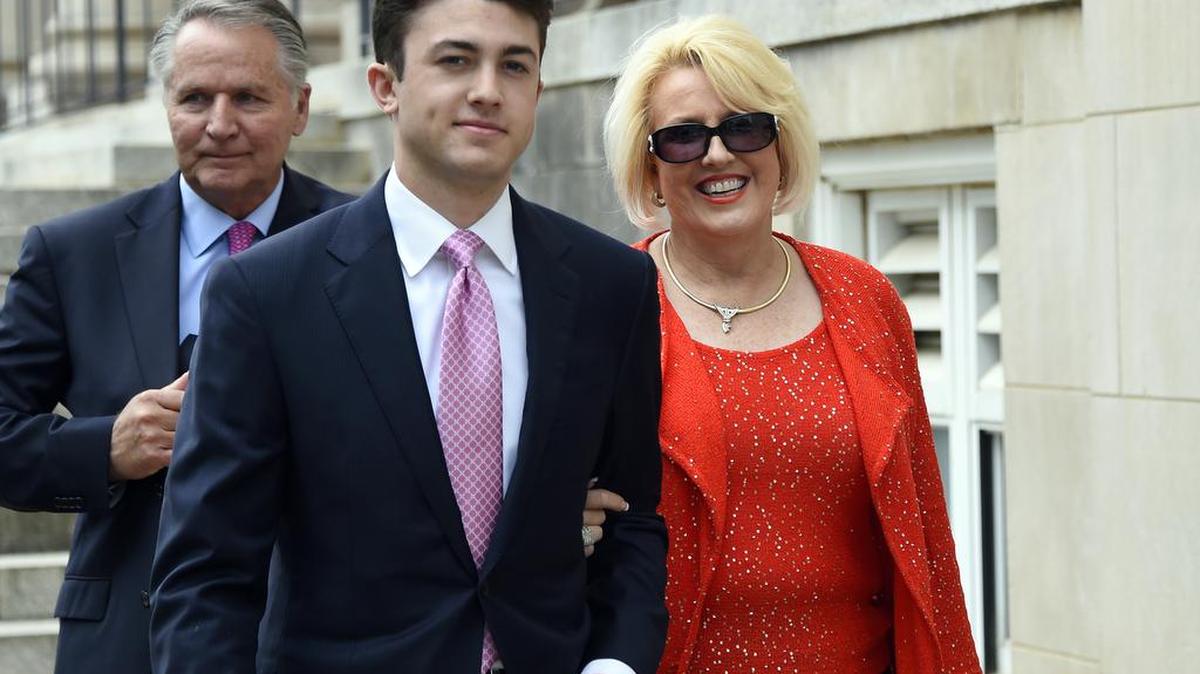 In this May 19, 2017, file photo, Brooke Covington, right, a member of the Word of Faith Fellowship church in Spindle, leaves a hearing at Rutherford County Courthouse, background, in Rutherfordton accompanied by an attorney, Joshua Valentine, left, and her husband, Kent Covington. A judge held a juror in contempt and declared a mistrial Tuesday, June 6, in the case of the North Carolina church minister charged in the beating of a congregant who says he was attacked to expel his “homosexual demons.”