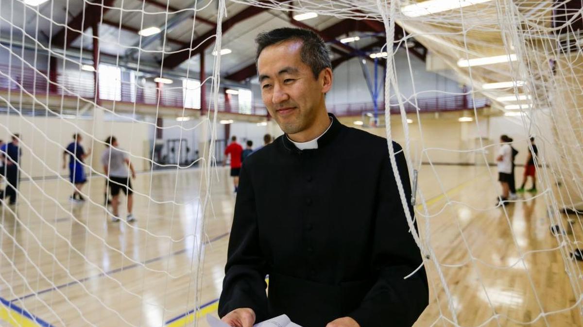 In this May 12 photo, the Rev. Joseph Lee, academic dean and basketball coach, leaves the gym at Our Lady of Guadaloup Seminary in Denton, Neb., as seminarians play basketball. Seminary life is extraordinarily regimented. Along with chanting four times a day and attending classes, they eat meals together and exercise together.