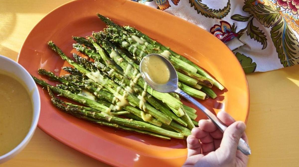 This November 2016 photo shows roasted asparagus with lemon dressing in New York. This lemon sauce is a simple way to dress up roasted asparagus, the pinup vegetable of spring. It’s also good for any simply cooked asparagus, such as grilled, steamed or sauteed.