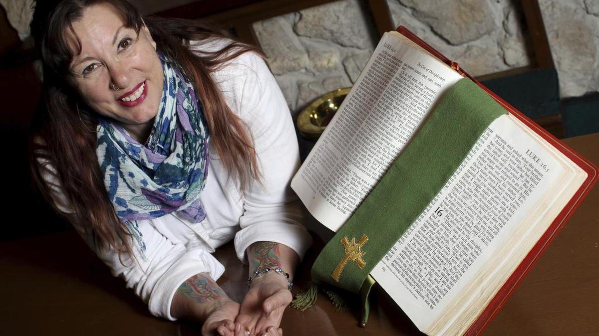 Pastor Elizabeth Bell poses at Asbury United Methodist Church in Burlington, Iowa. With a nose ring and tattooed arms, Bell doesn’t look like your typical pastor. The tattoos on her forearms — one of the New Testament Greek word for rejoice, and the other a brightly colored communion cup — aren’t the only ones she has, but they’re the only ones she’ll let people see, she told The Hawk Eye. She got the tattoos about a year ago, and they have served her well as a means of striking up a conversation about faith, something that comes in handy during a time when church pews are becoming more difficult to fill.