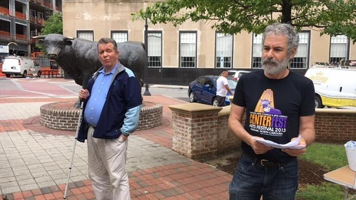 Retired Judge Craig Brown, left, and Dan Ellison unveil one of nine DADA (Durham Audio Described Art) projects Tuesday.