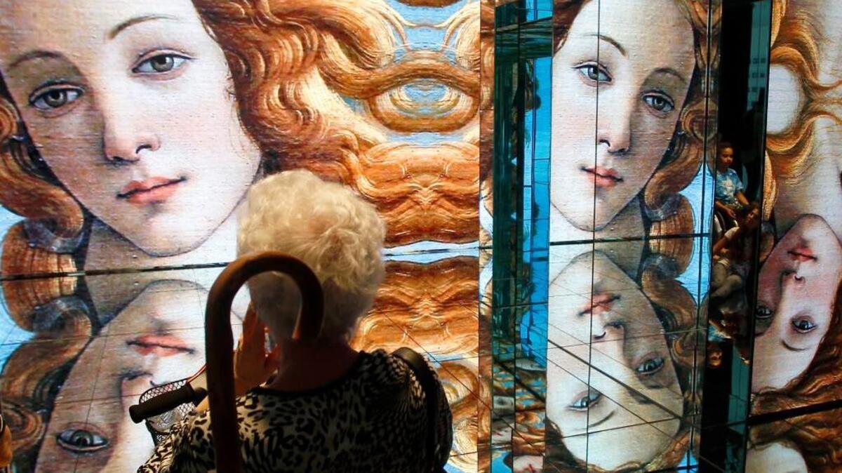 In this Friday, June 5, 2015 file photo a person visits the Italian pavilion as Sandro Botticelli's mid 1480s painting of Birth of Venus is displayed on the walls at the Expo 2015 in Rho, near Milan, Italy. A new exhibition of Italian Renaissance master Sandro Botticelli's paintings has opened in Boston, "Botticelli and the Search for the Divine" at Boston's Museum of Fine Arts.