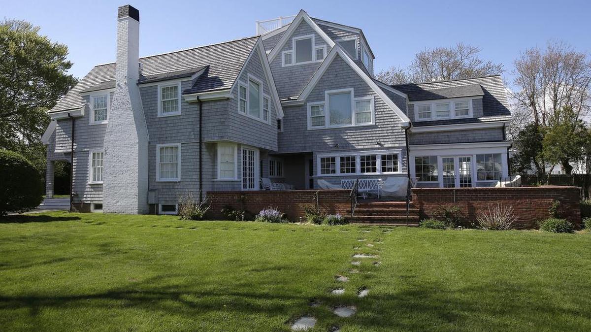 In this Monday, May 8, 2017 photo, a house that was once the residence of President John F. Kennedy is surrounded by trees in Hyannis Port, Mass. Pieces of the home can now be called pieces of art. Floorboards, window panes, light fixtures, copper pipes, shingles, faded wallpaper, rusted nails and even a metal hook that once held a porch swing are among ordinary items salvaged during an overhaul of the president's former home on Cape Cod and transformed by local artists into mixed media artworks inspired by the president who was born 100 years ago this month.