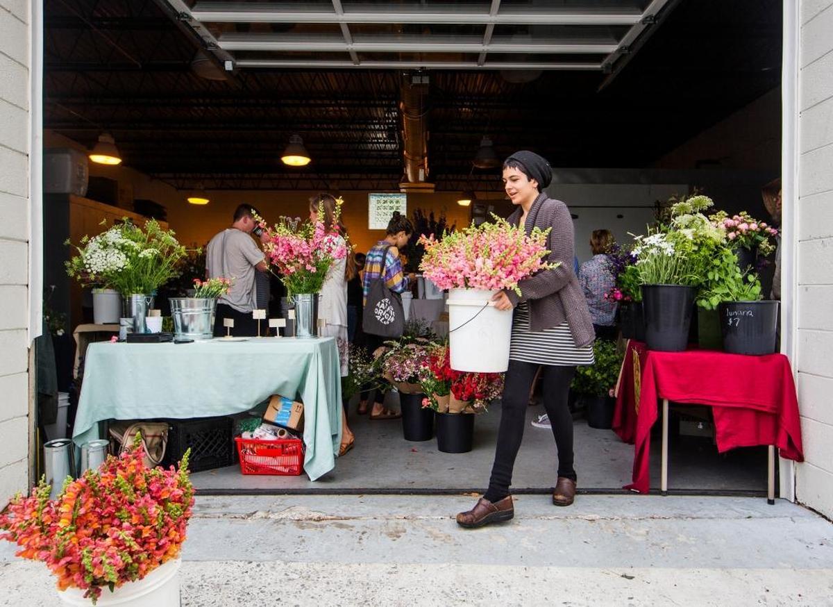 Maggie Smith, owner of Pine State Flowers, buys flowers from Piedmont Wholesale Flowers during its grand opening on Thursday.