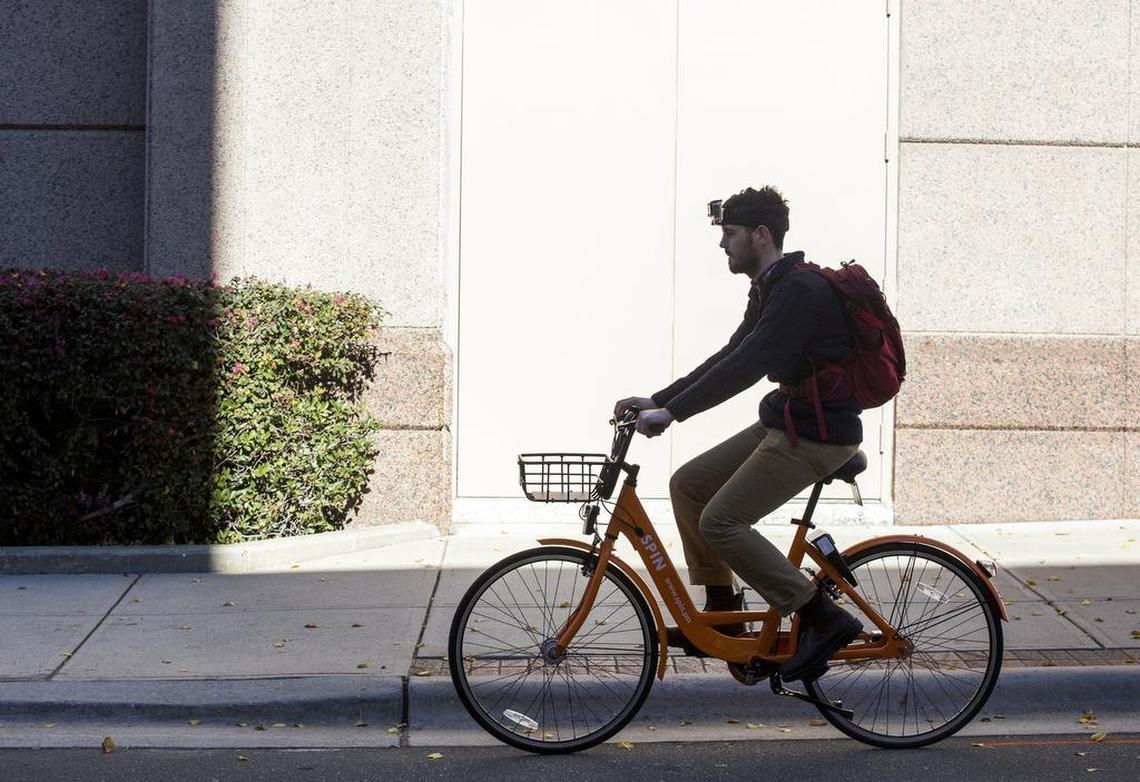 Zach Eanes, a business reporter at The Herald-Sun, tests out one of Durham's new bike share program bikes from Spin.