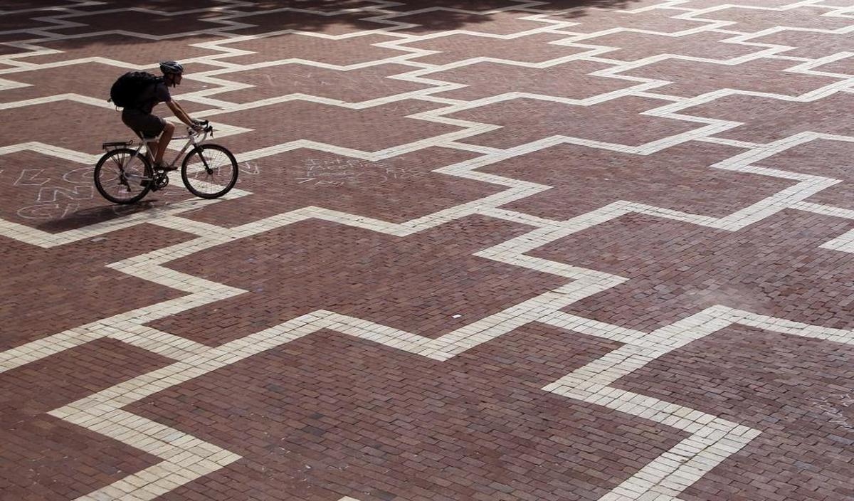 A bike rider crosses the Brickyard on the North Carolina State University campus. Officially named University Plaza, the Brickyard is a hallowed place where the NCSU community has criss-crossed, congregated and celebrated for decades.